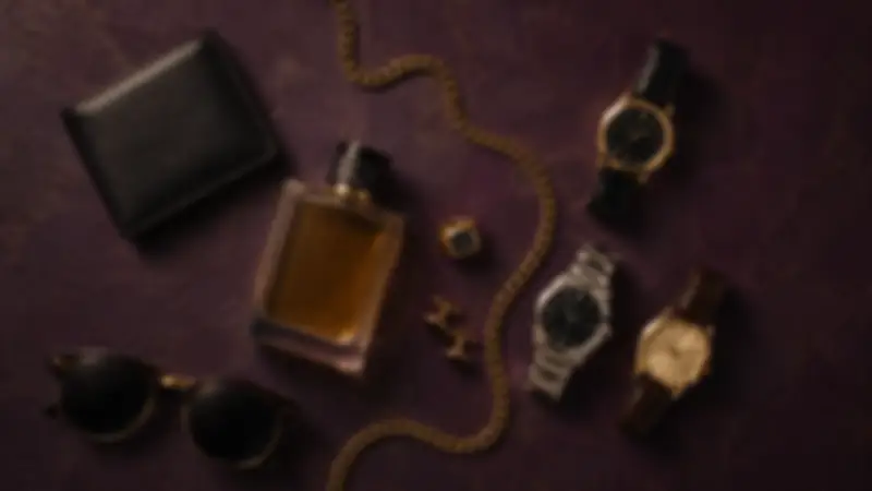Black wallet, round sunglasses, amber fragrance, three watches, and gold accessories on aubergine plaster.